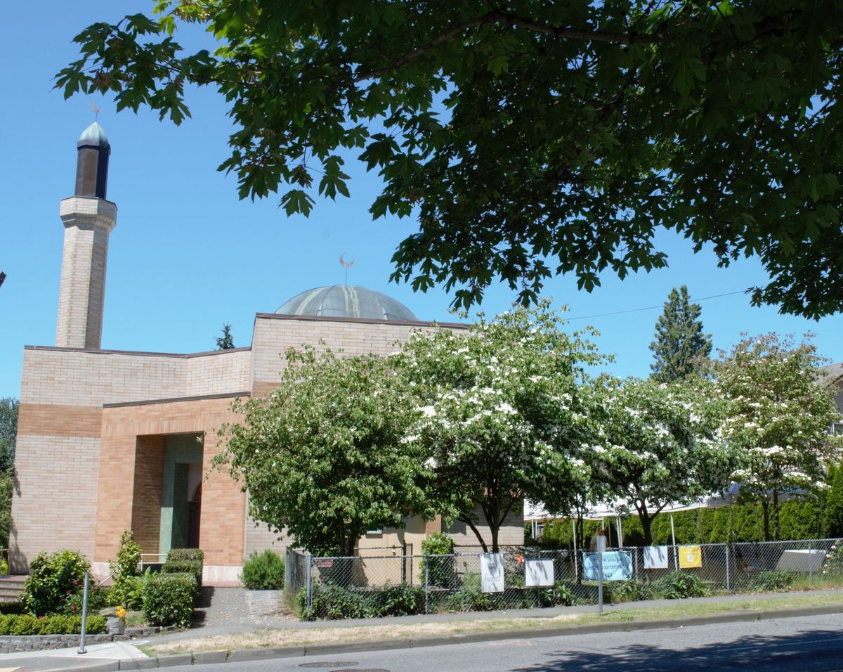 Idris Mosque in Seattle’s Northgate neighborhood: the brick prayer hall, minaret and dome behind summer trees